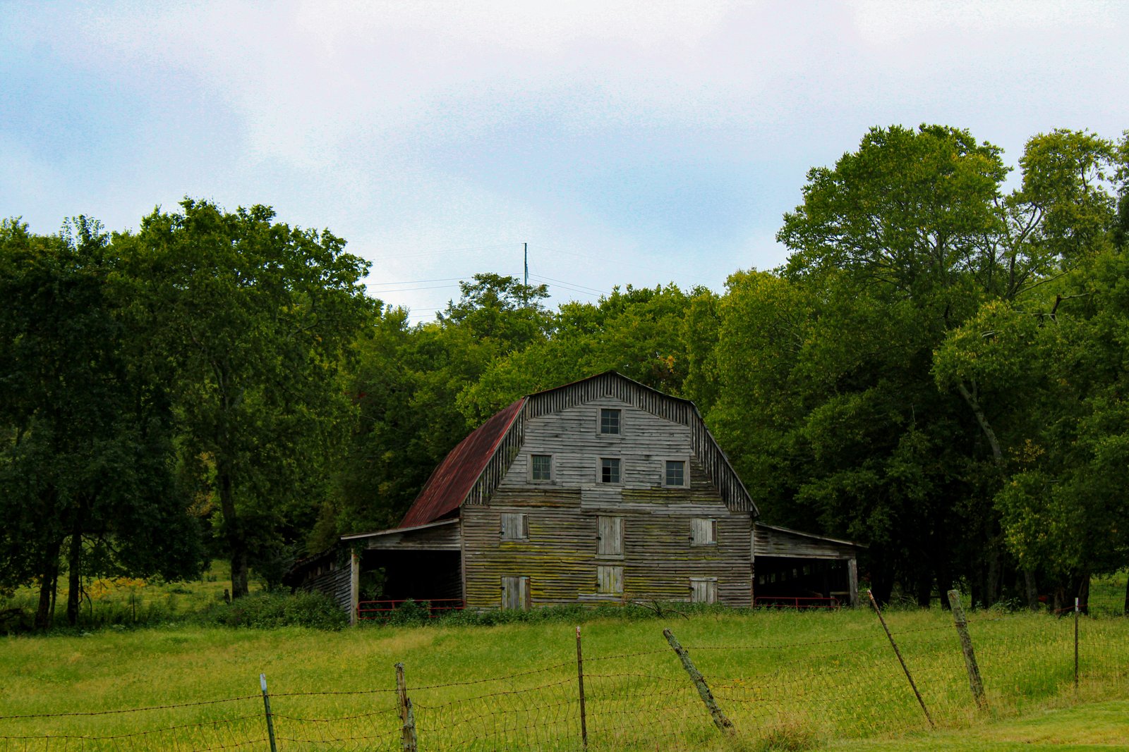 A barn surrounded by trees.